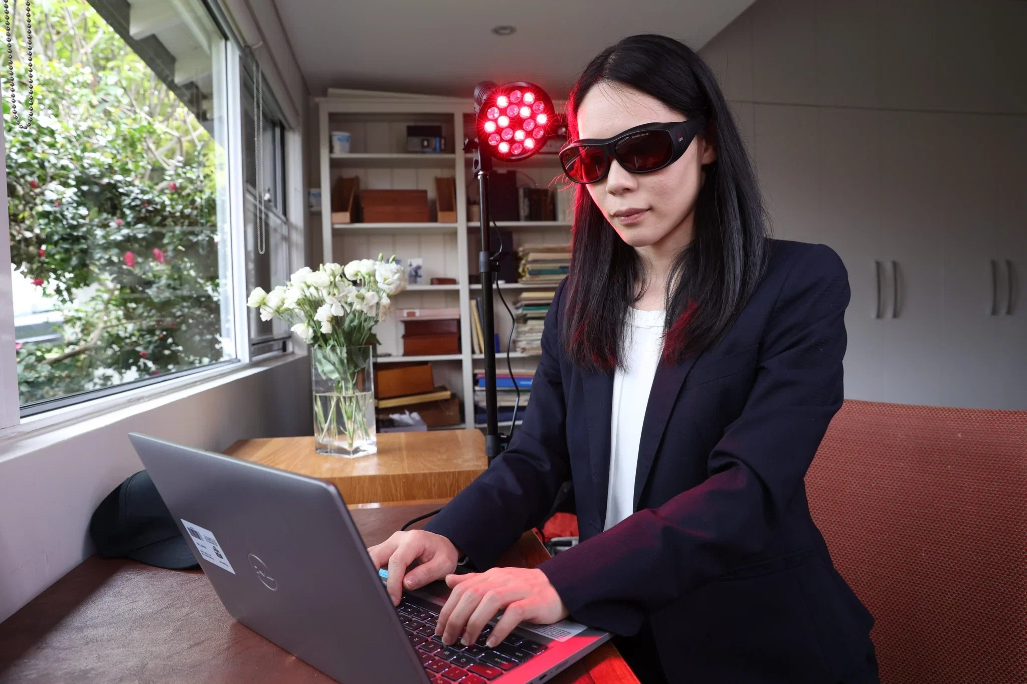 Woman working on a laptop while wearing HeroFilter glasses