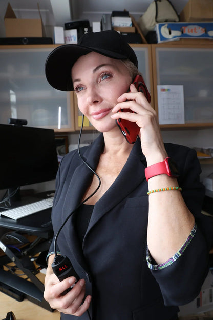 Woman wearing the HeroHat LED cap while using a phone