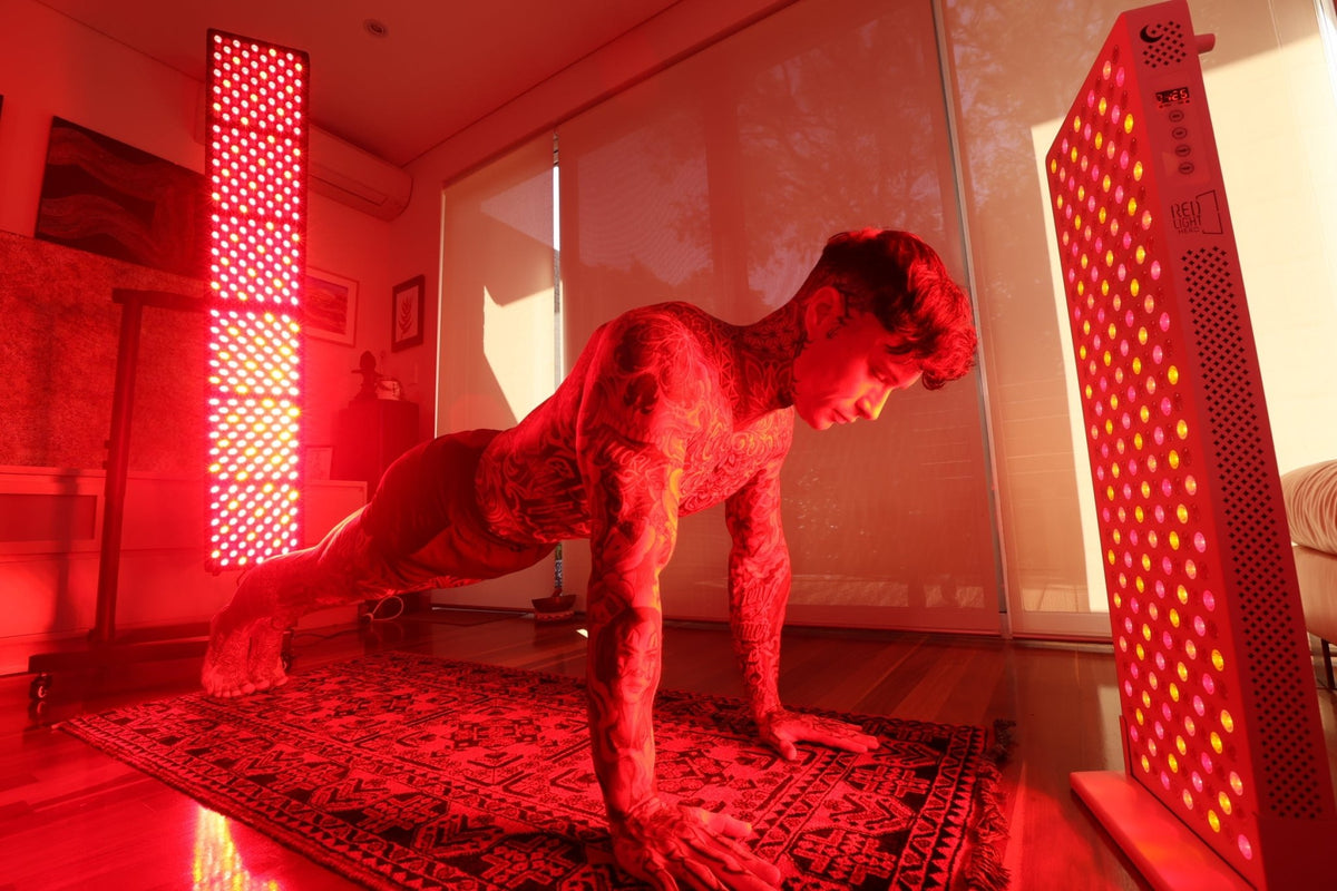 Man exercising between two vertical red light therapy panels