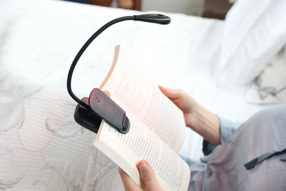 Close-up of the HeroReader lamp clipped to an open book