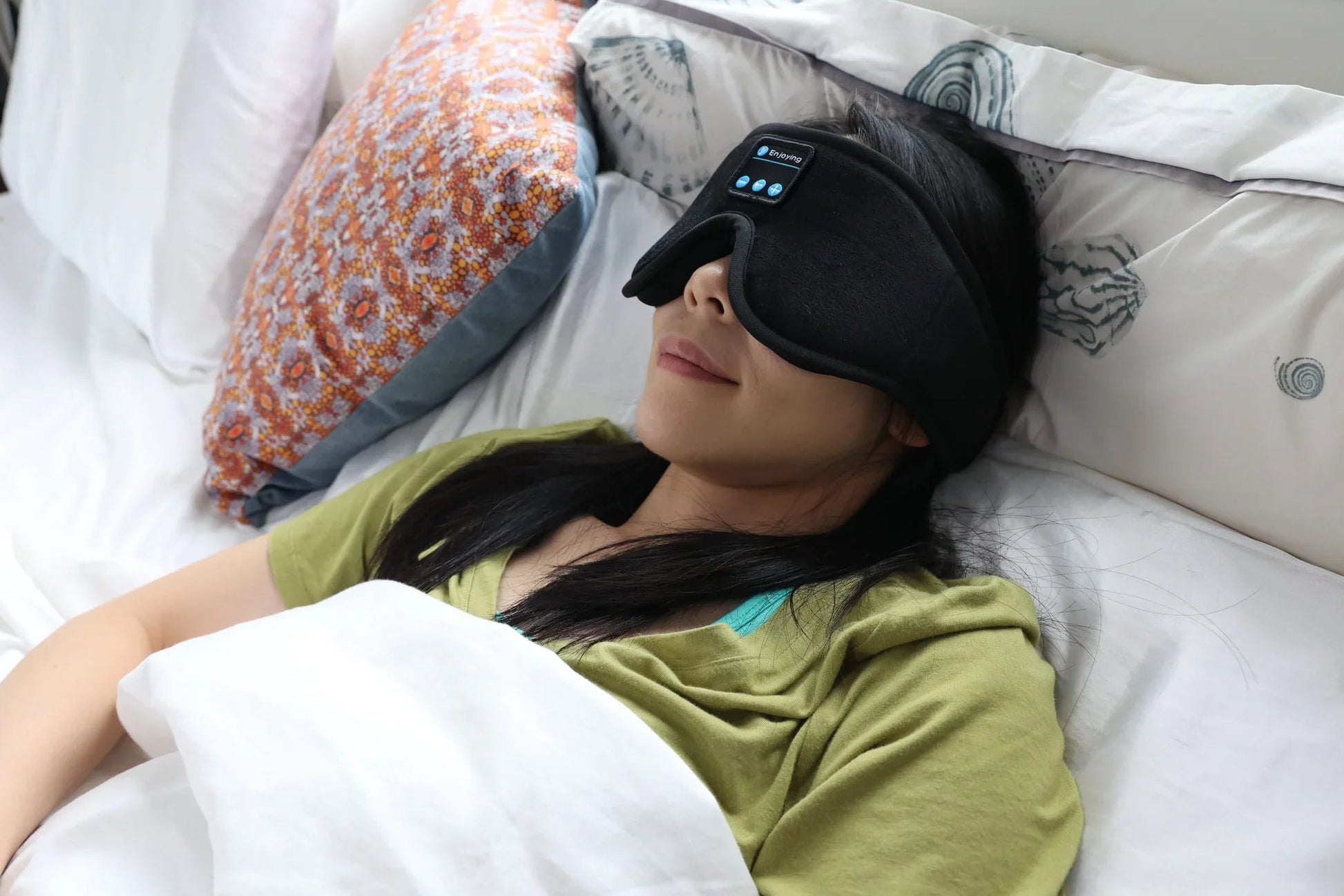 Woman resting under covers with the HeroSleep Soothe sleep mask