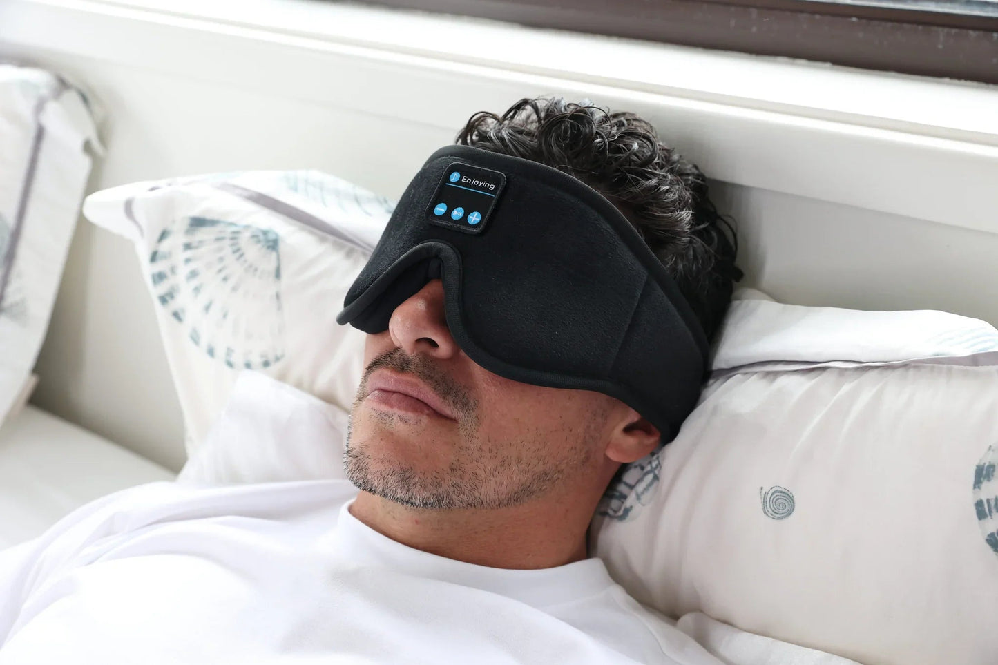 Man resting in bed wearing the HeroSleep Soothe sleep mask