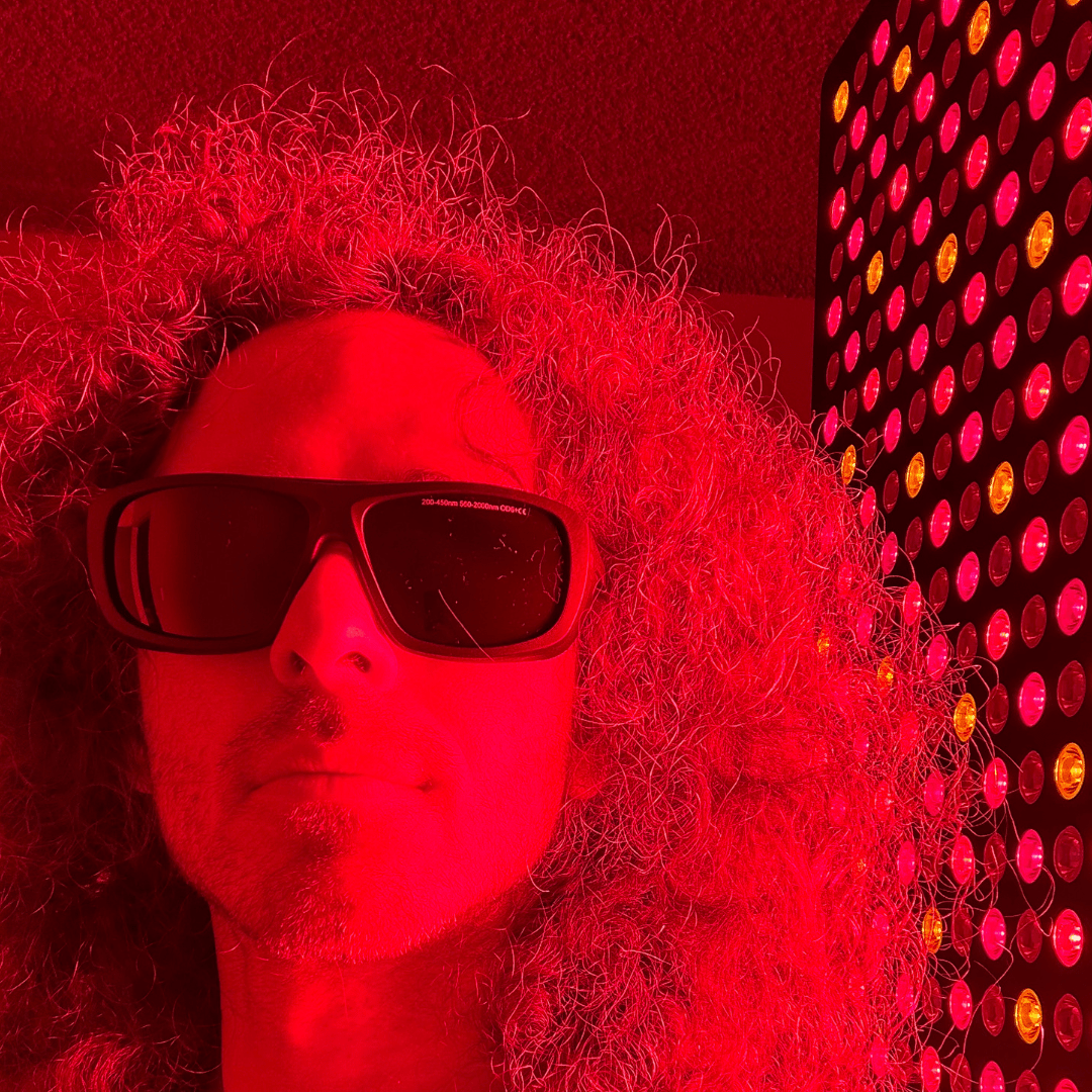 Woman wearing protective glasses beside an illuminated red light panel