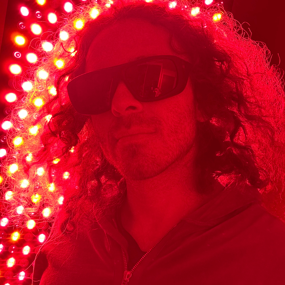Man wearing protective glasses beside an illuminated panel