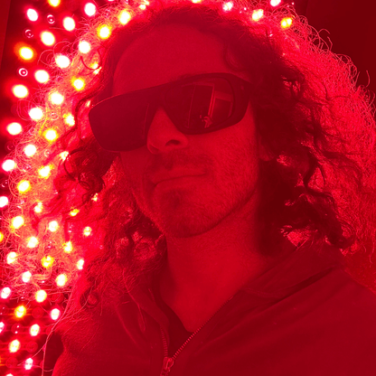 Man wearing protective glasses beside an illuminated panel