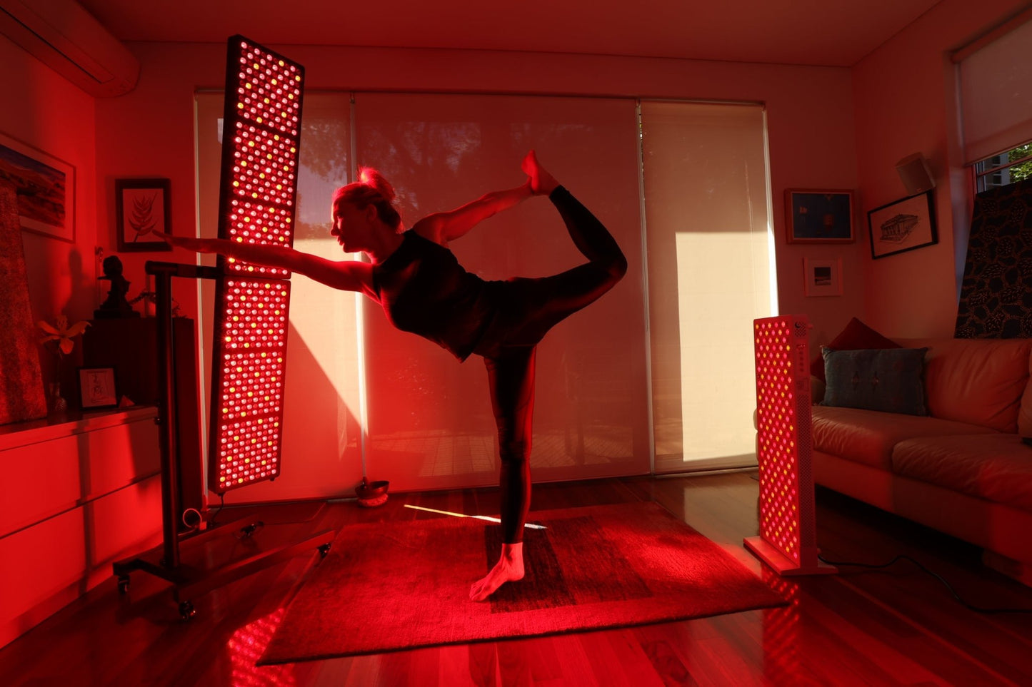 Woman in a standing balance yoga pose between two Hero300 panels